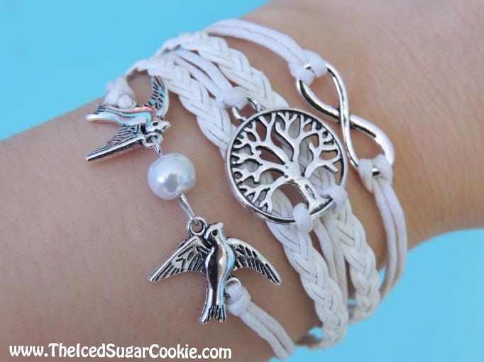 www.TheIcedSugarCookie.com The Iced Sugar Cookie offers tree of life bracelets. White leather tree of life bracelet with dove and faux pearl and infinity love sign. 